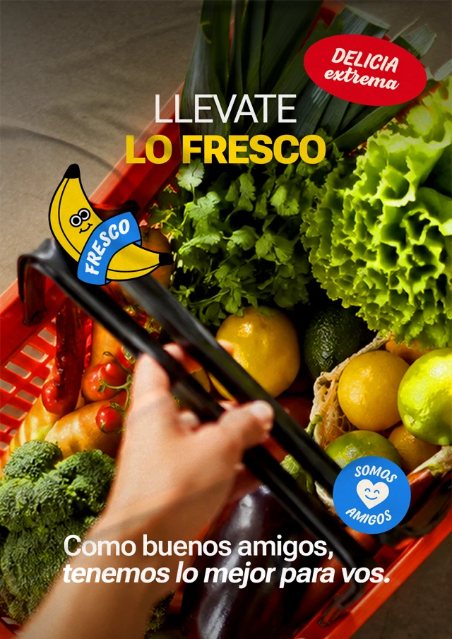 Afiche de La Amistad para vía pública, con frutas y verduras frescas y el mensaje “Llevate lo fresco”, colocado sobre una pared.