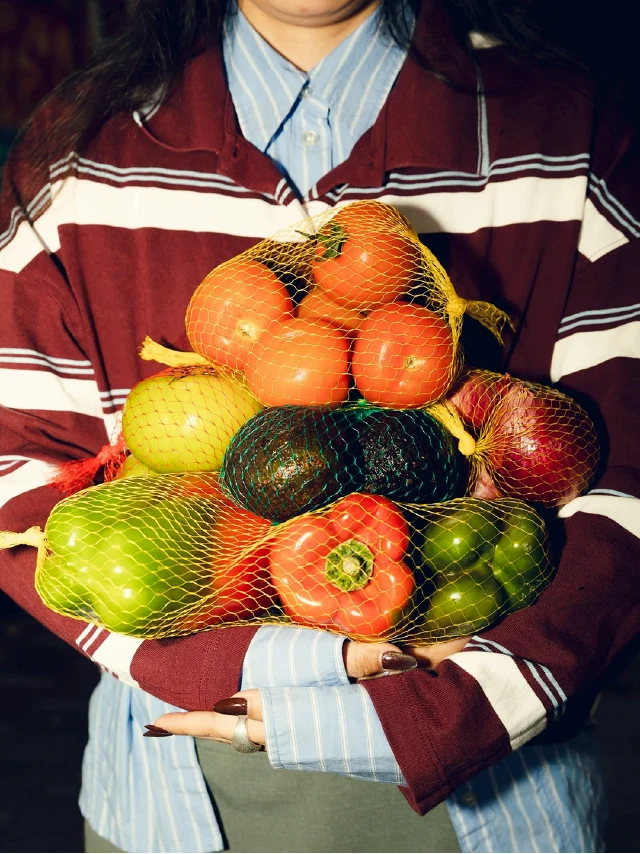 Fotografía de una persona sosteniendo una canasta con frutas y verduras frescas de La Amistad